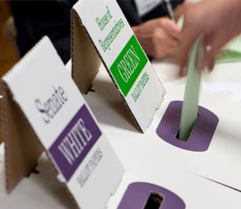 Casting a senate vote in the ballot box at a polling booth.